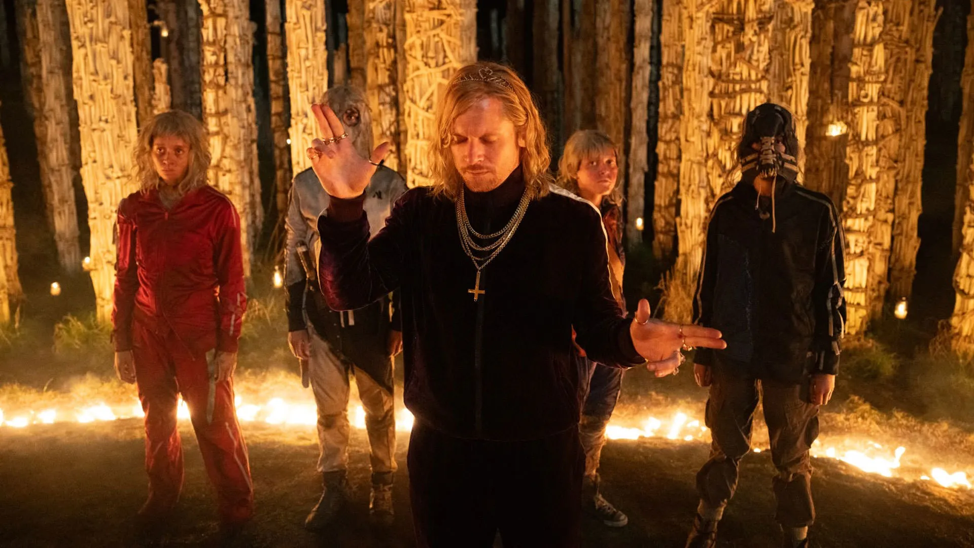 جک اوکانل با گرمکن ورزشی مقابل الفی ویلیامز و سه نفر دیگر و آتش و استخوان ایستاده است در نمایی از فیلم ۲۸ سال بعد معبد استخوان نیا داکوستا