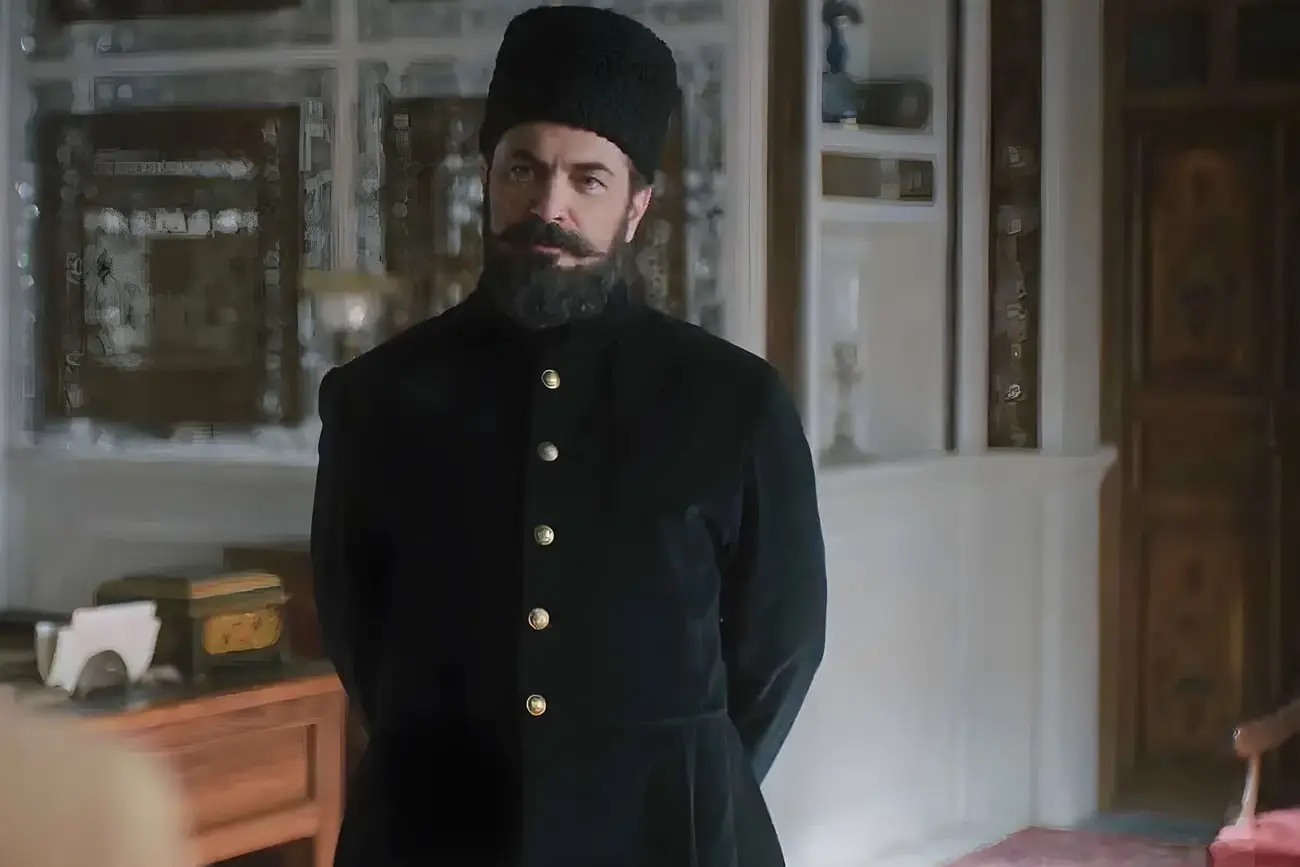 بازیگر سریال سرخ و سیاه با لباس سیاه و کلاه پشمی
