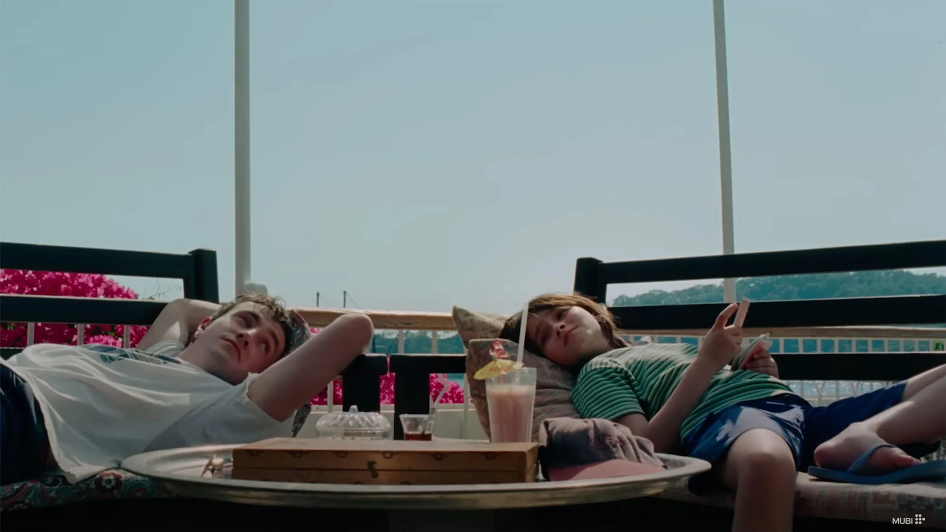 پل مسکال و فرنکی کوریو روی صندلی‌ دراز کشیده‌اند در نمایی از فیلم پس از آفتاب به کارگردانی شارلوت ولز