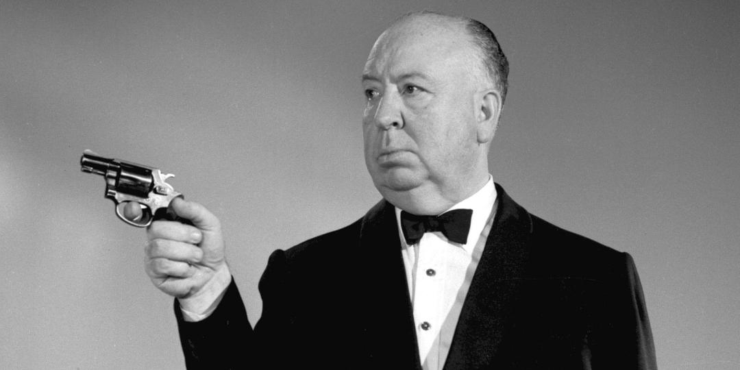 آلفرد هیچکاک (Alfred Hitchcock) در حال نگه داشتن یک هفت‌تیر
