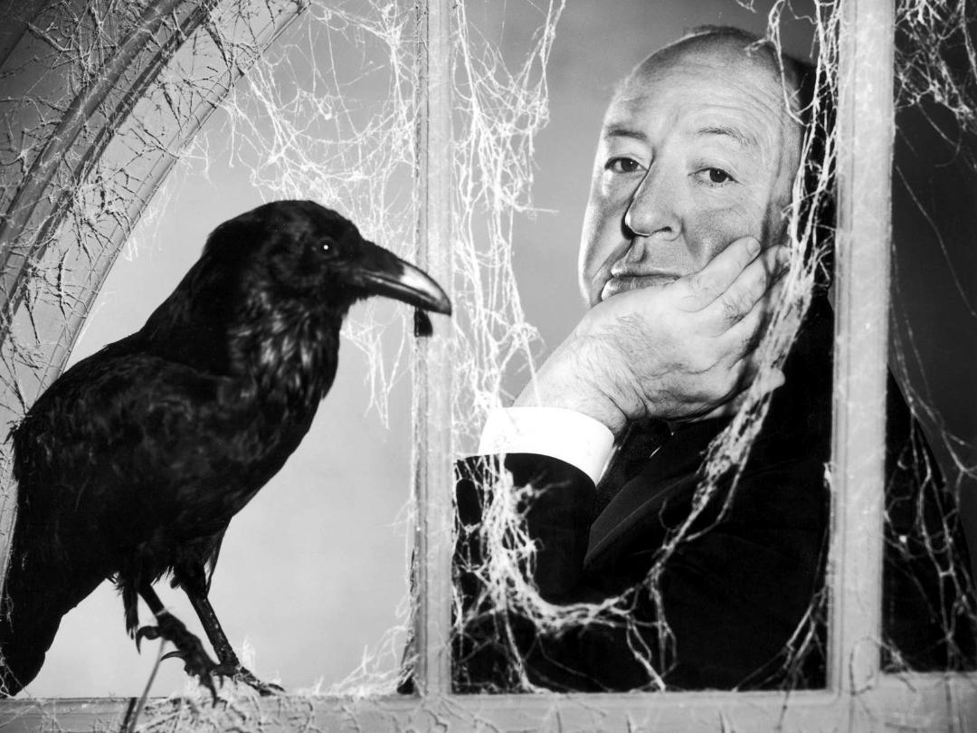 آلفرد هیچکاک (Alfred Hitchcock) در کنار یک کلاغ سیاه پشت تار‌های عنکبوت
