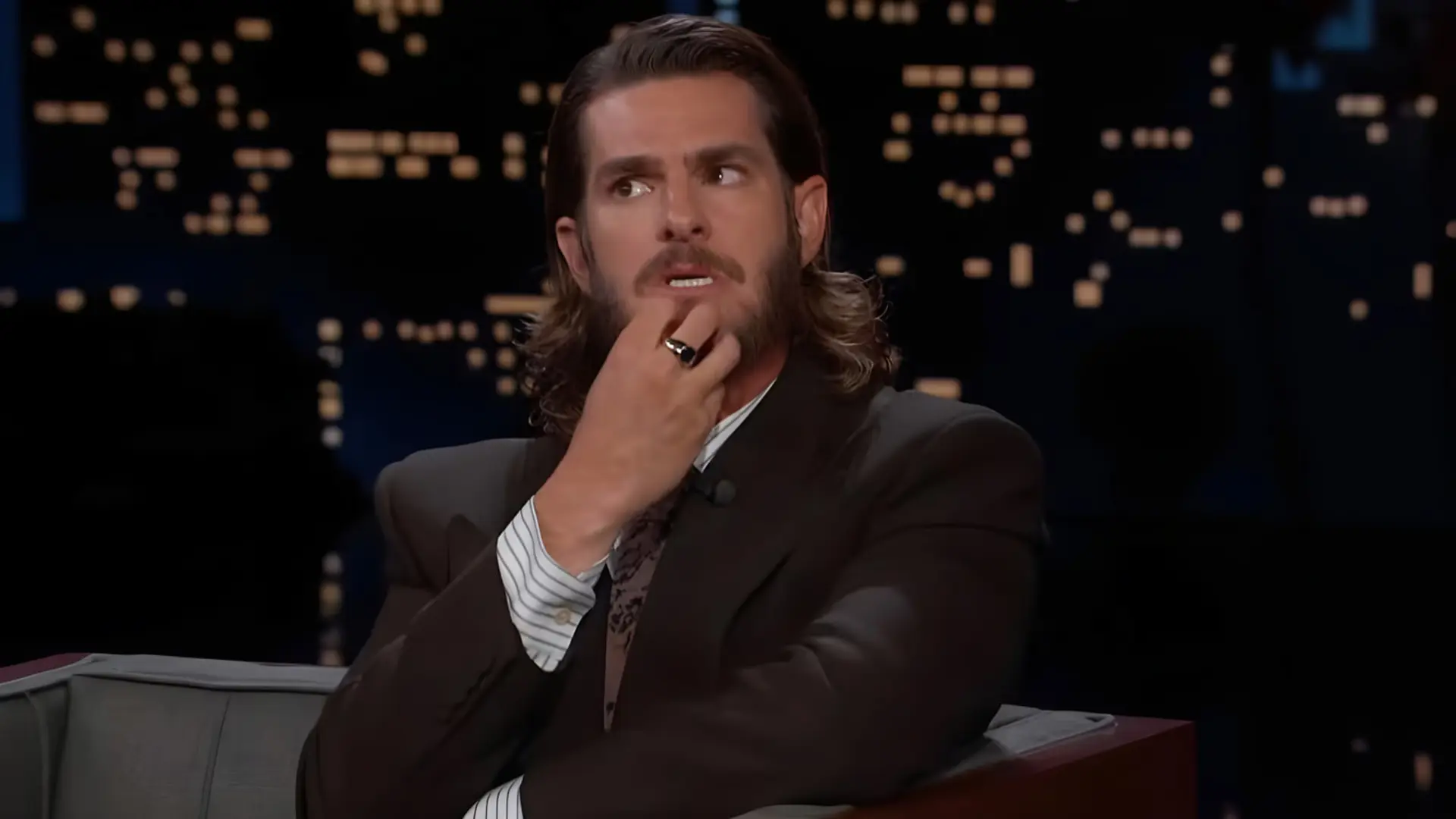 اندرو گارفیلد (Andrew Garfield) در حالی که دستش را زیر چانه گذاشته نشسته است