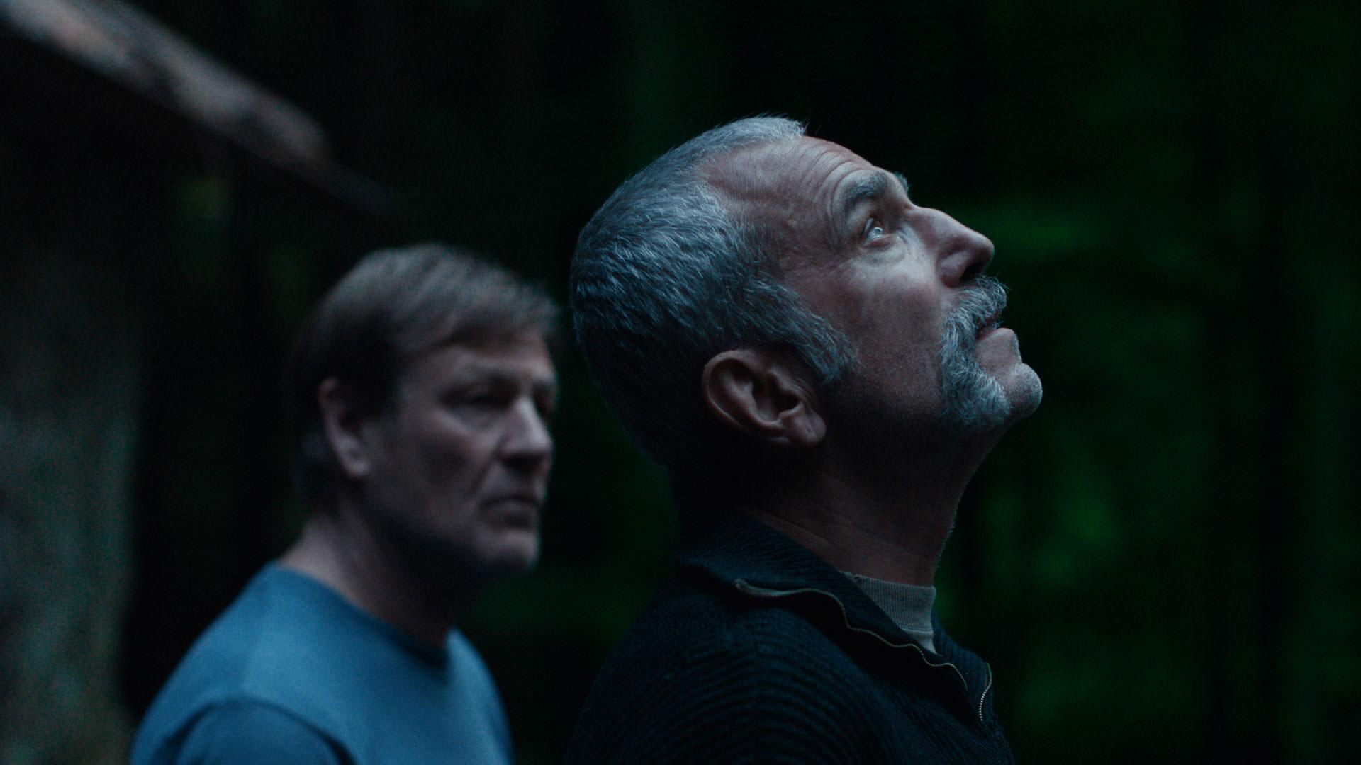 دنیل دی لوئیس ایستاده جلوتر از شان بین که در پس‌زمینه دیده می‌شود در نمایی از فیلم آنمونی به کارگردانی رونن دی لوئیس