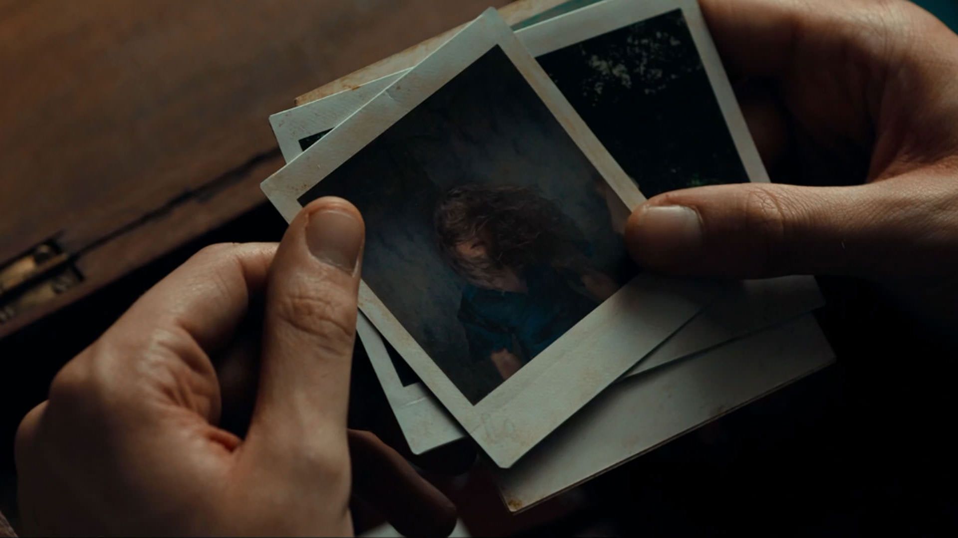 تعدادی عکس پولاروید در نمایی از فیلم آنمونی به کارگردانی رونن دی لوئیس