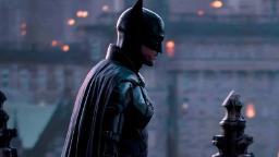 بتمن (Batman) با لباس سیاه در صحنه فیلم‌برداری ایستاده است