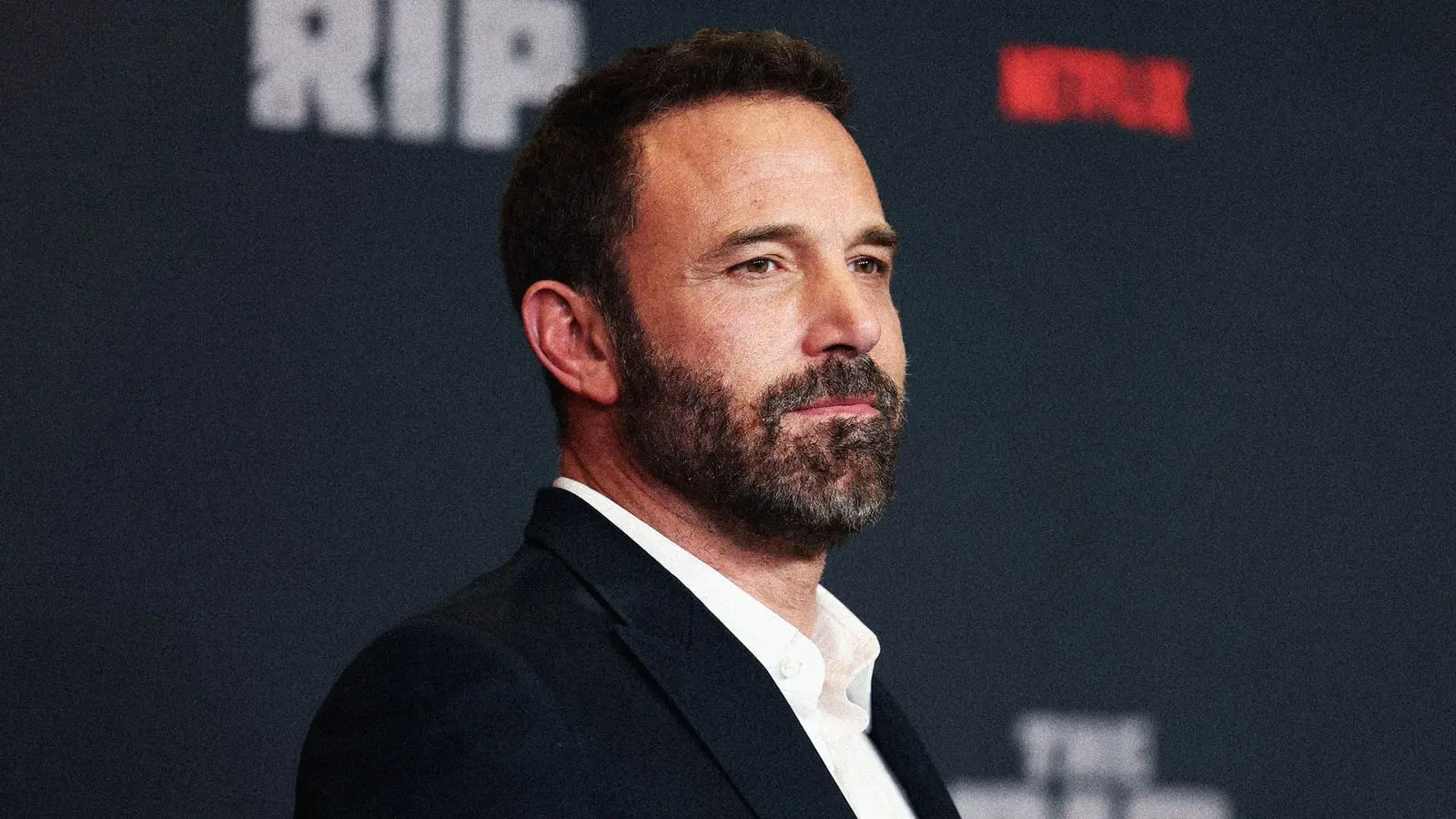 بن افلک (Ben Affleck) با ریش و کت سرمه‌ای در یک مراسم رسمی