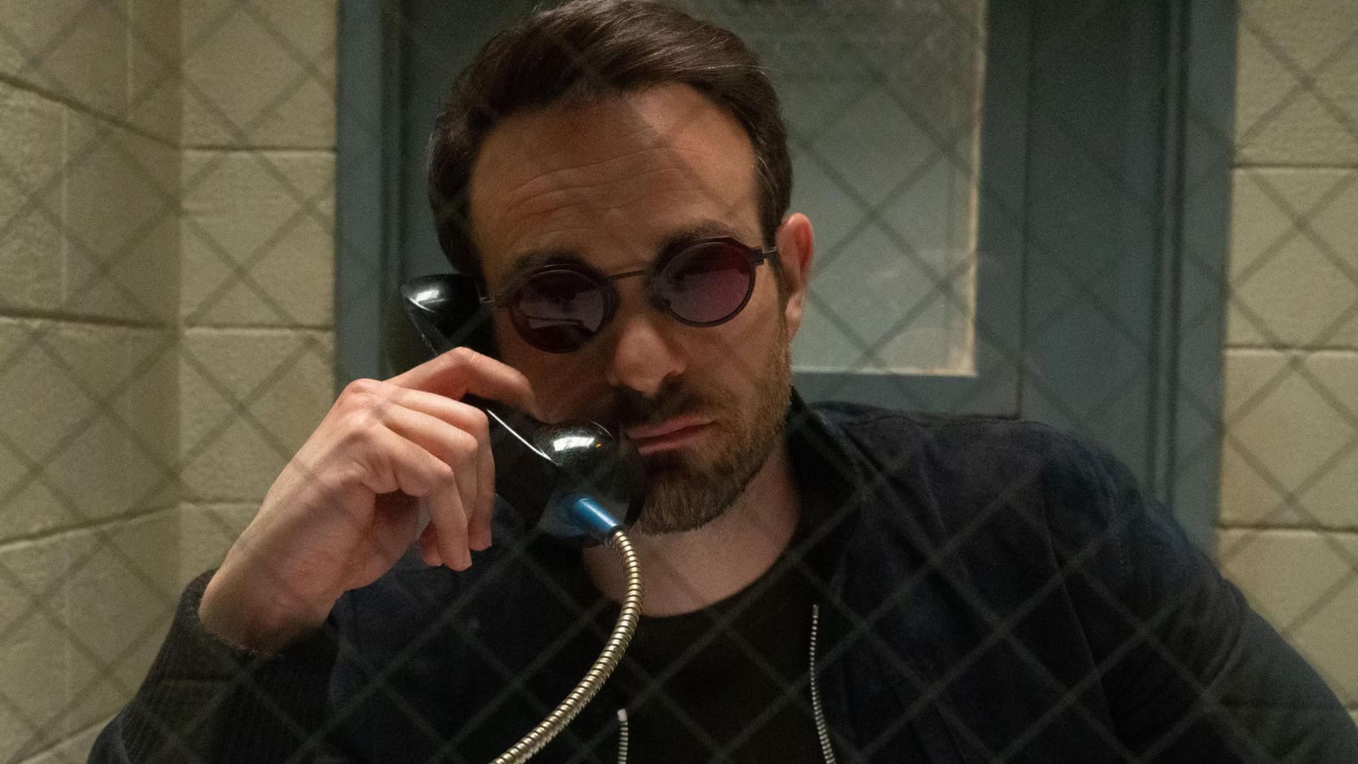 چارلی کاکس (Charlie Cox) با عینک تیره در حال صحبت با تلفن