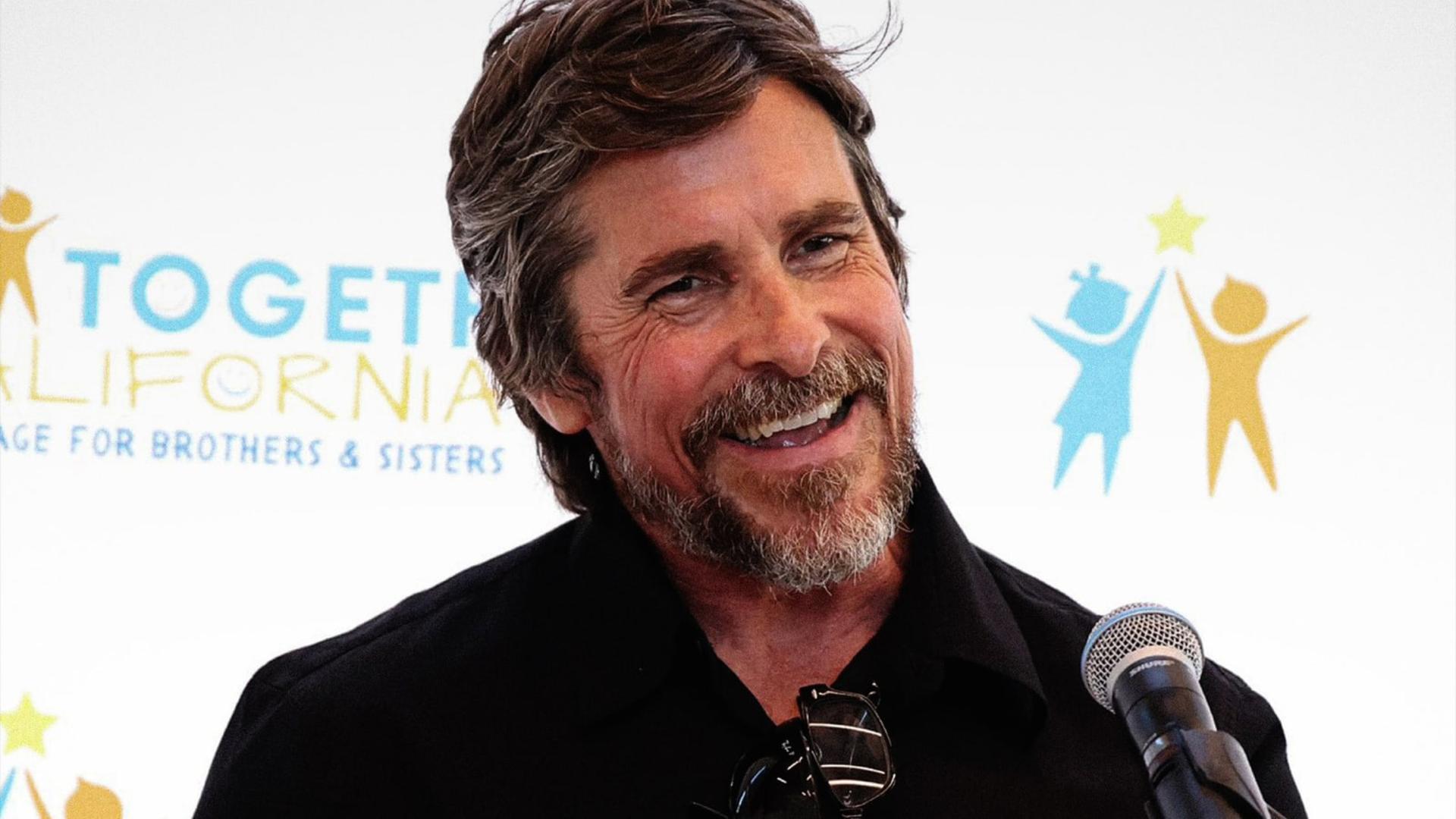 کریستین بیل (Christian Bale) در حال لبخند زدن در یک رویداد خیریه