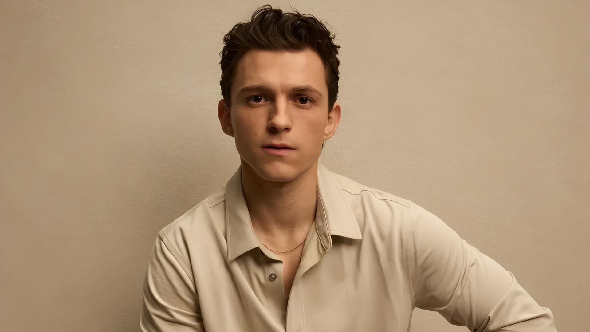 تام هالند (Tom Holland) با پیراهن روشن در مقابل پس‌زمینه ساده