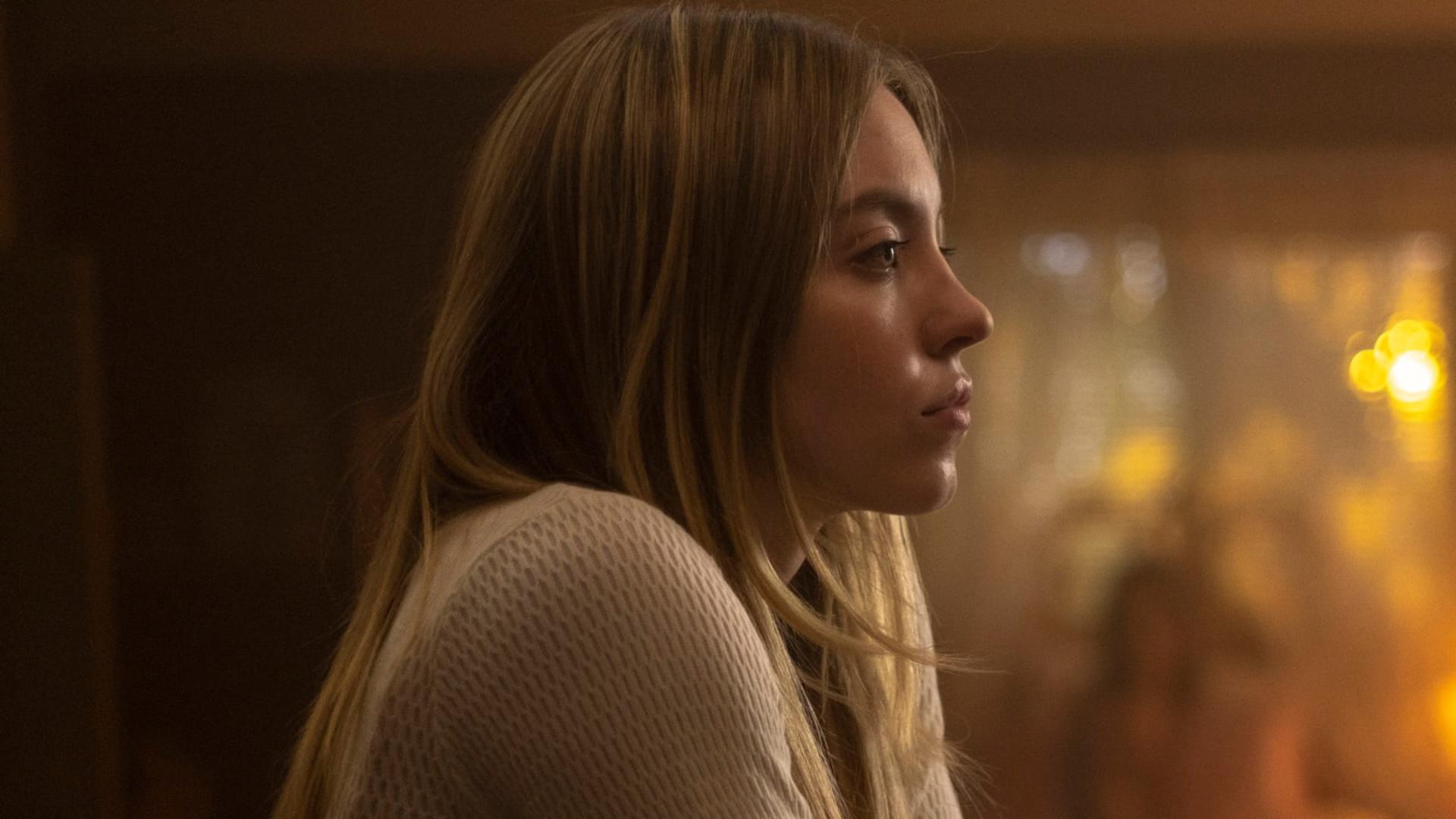 سیدنی سوئینی (Sydney Sweeney) در نمای نیم‌رخ در محیطی با نور گرم