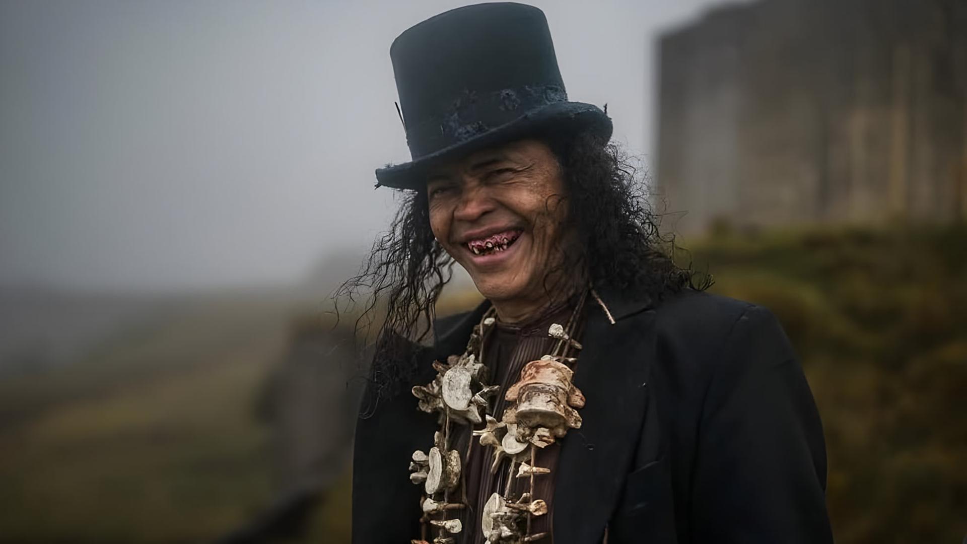 مردی با کلاه سیلندر (Top Hat) و گردنبندهای بزرگ در فضای مه‌آلود