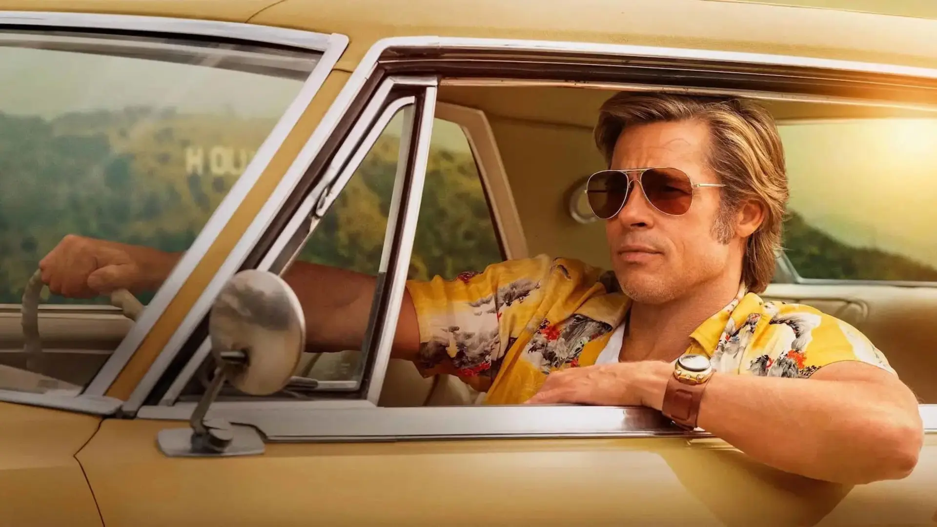 برد پیت (Brad Pitt) با عینک آفتابی پشت فرمان خودروی کلاسیک نشسته است