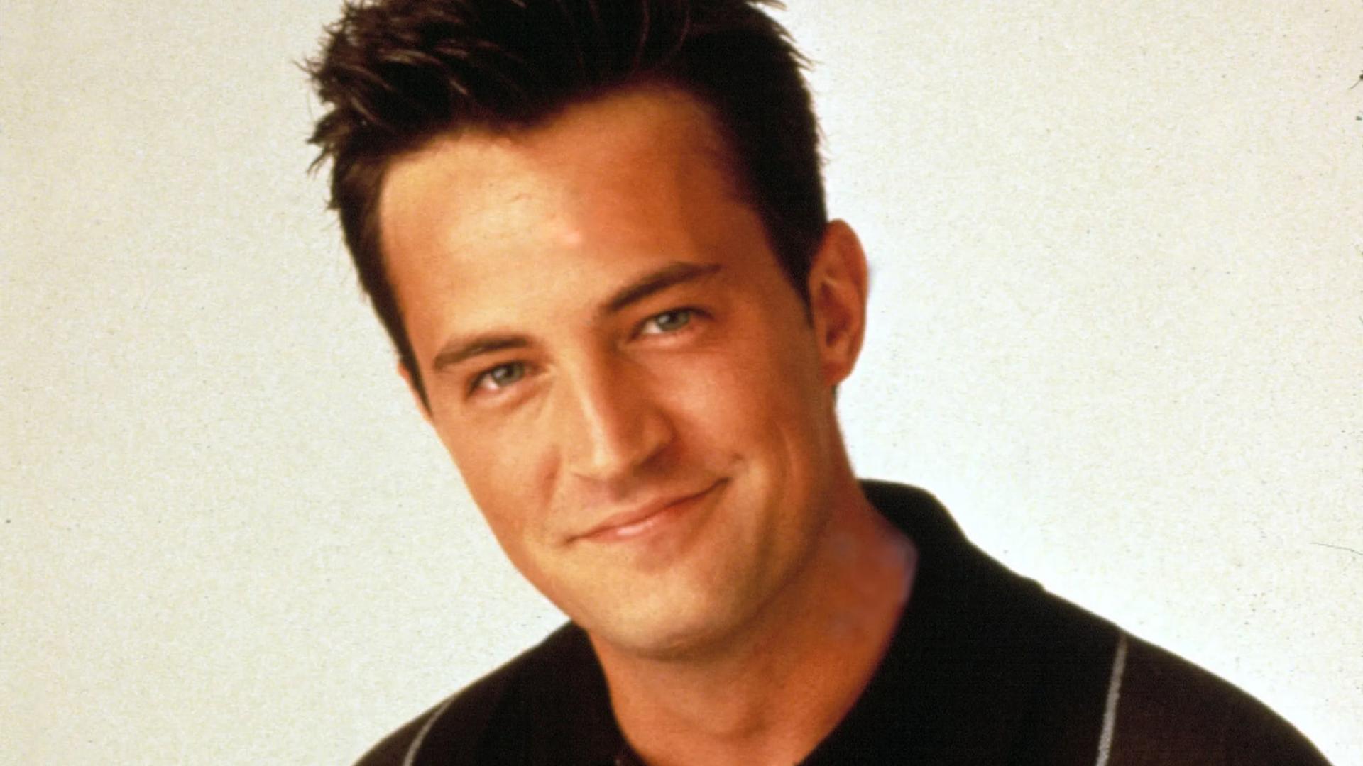 متیو پری (Matthew Perry) با لبخندی ملایم در مقابل پس‌زمینه روشن