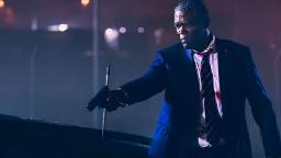ساموئل ال جکسون (Samuel L. Jackson) با کتی رسمی و اسلحه در شب