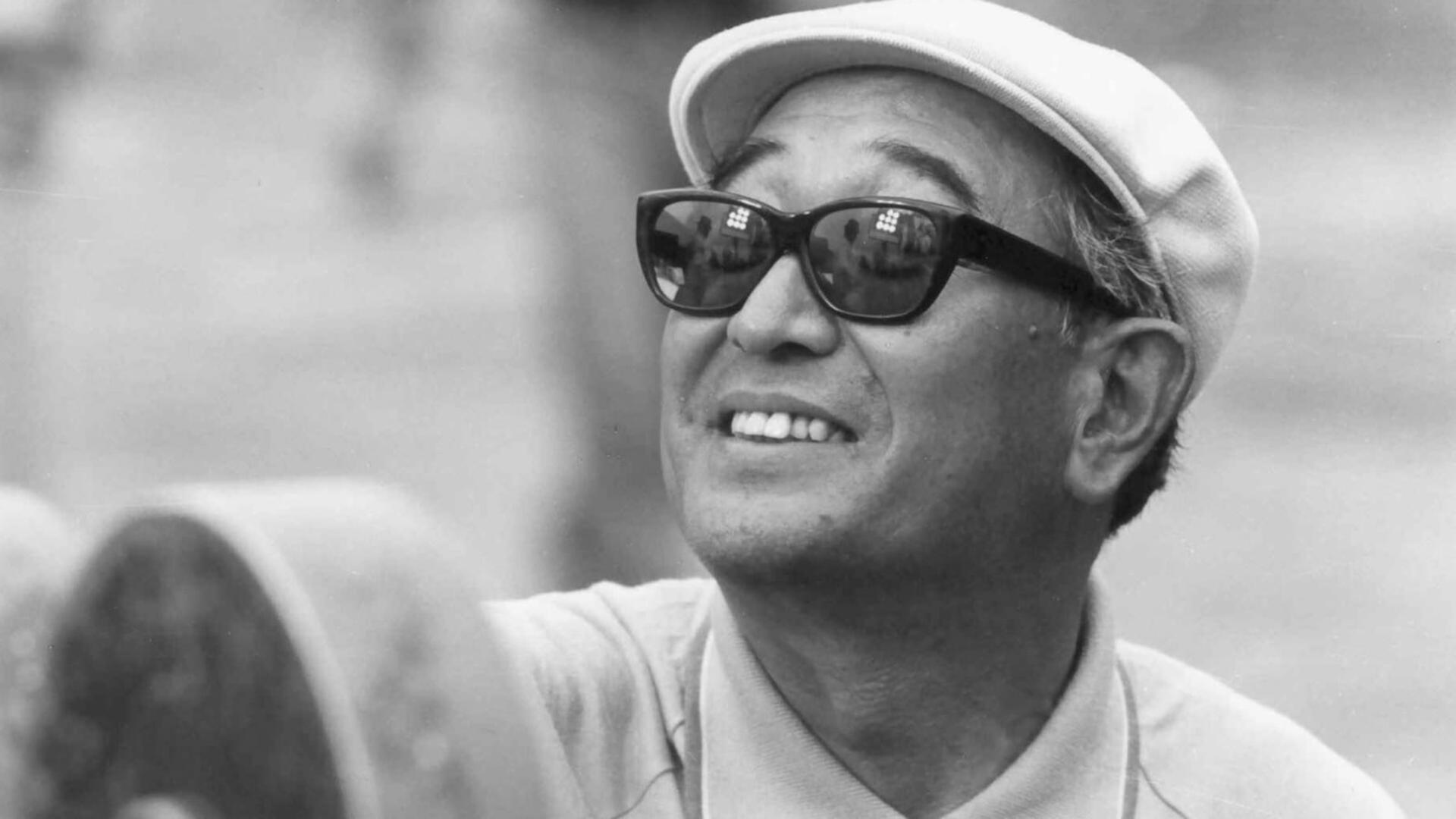 آکیرا کوروساوا (Akira Kurosawa) با عینک آفتابی و کلاه لبه‌دار