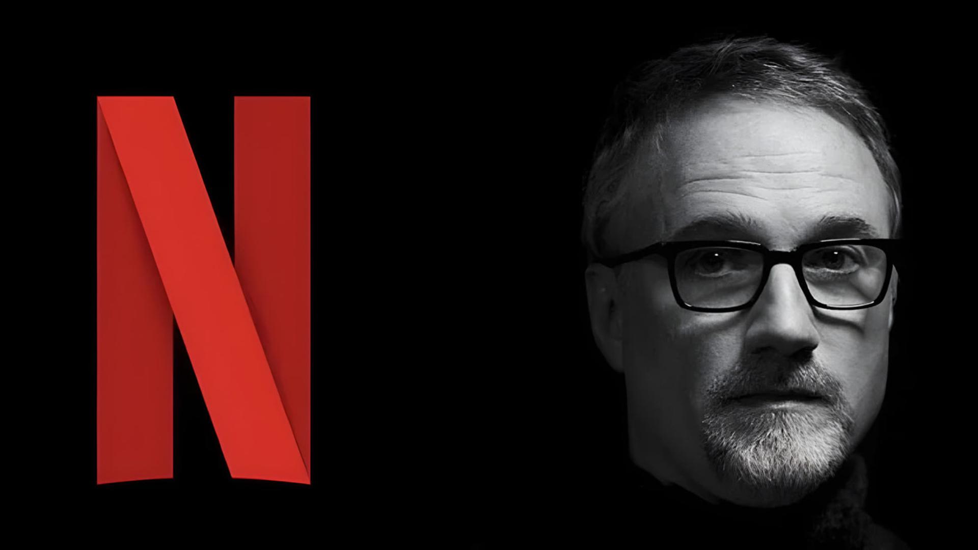 دیوید فینچر (David Fincher) در کنار لوگوی قرمز رنگ نتفلیکس