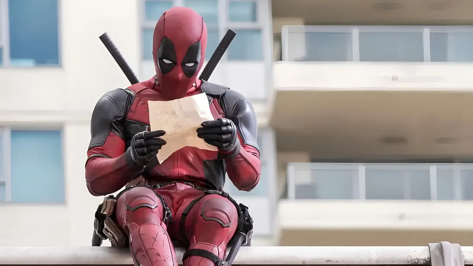 کاسپلی ددپول (Deadpool) در حال خواندن یک کاغذ در فضای باز