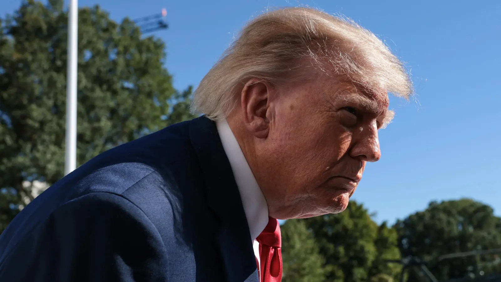 دونالد ترامپ (Donald Trump) با کت و کراوات قرمز در مقابل آسمان آبی
