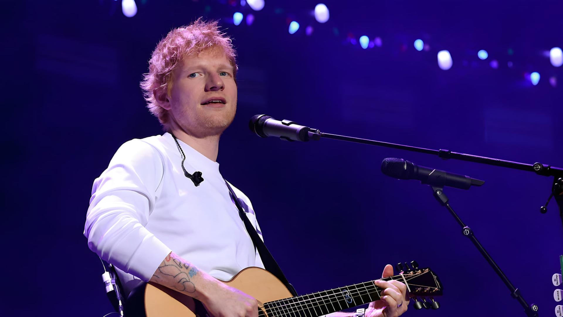اد شیرن (Ed Sheeran) در حال نواختن گیتار در کنسرت موسیقی