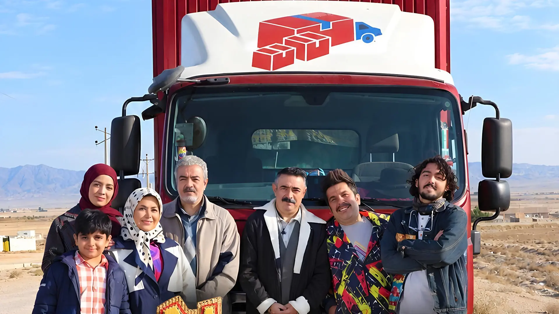 گروهی از بازیگران برنامه اسباب زحمت در کنار کامیون قرمز رنگ