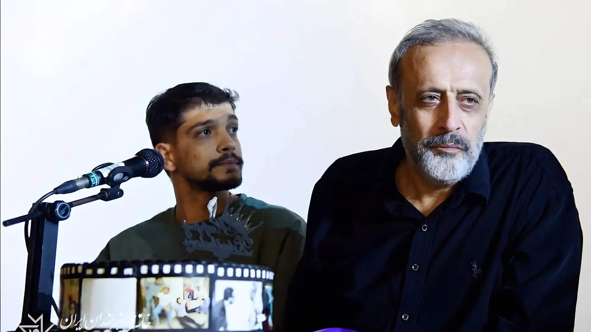 حمید نعمت‌الله (Hamid Neamatollah) در کنار یک خبرنگار پشت میکروفون