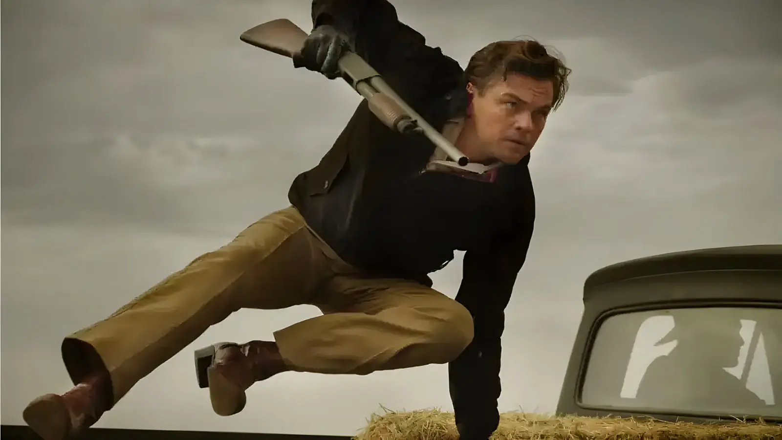 لئوناردو دی‌کاپریو (Leonardo DiCaprio) در حال حرکت با تفنگ در صحنه فیلم‌برداری