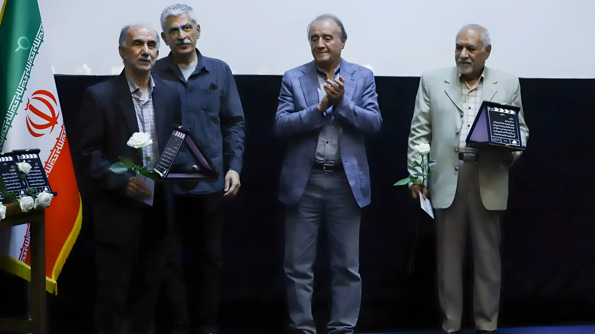هنرمندان سینما در مراسم تقدیر با تابلوی یادبود و گل سفید