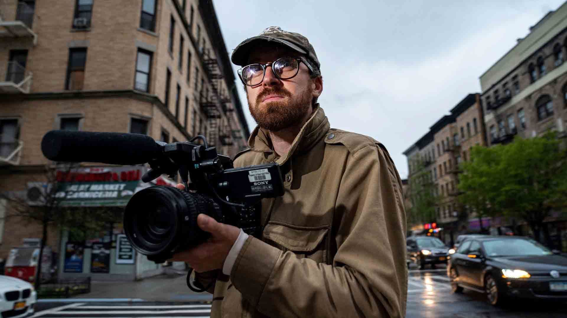 جان ویلسون با دوربین فیلمبرداری در سطح شهر در سریال How To with John Wilson