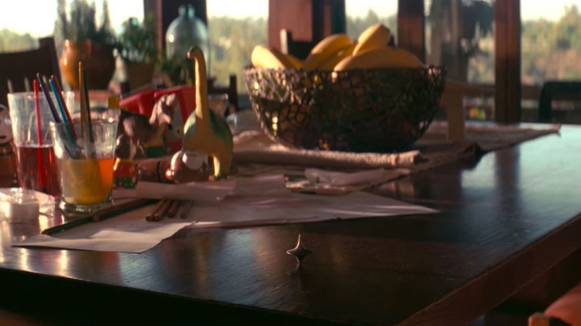 فرفره‌ای روی میز شلوغ یک خانه میچرخد در نمای پایانی فیلم تلقین به کارگردانی کریستوفر نولان