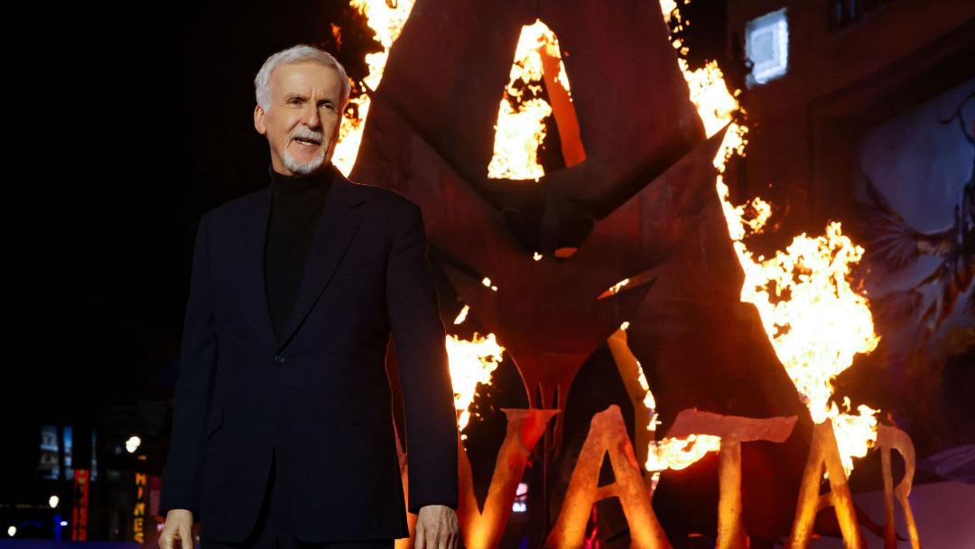 جیمز کامرون (James Cameron) در مقابل لوگوی آتشین فیلم آواتار