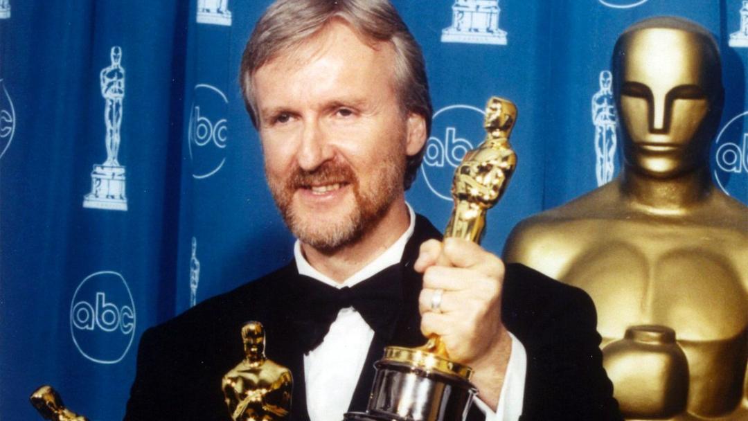 جیمز کامرون (James Cameron) در حال نگه داشتن تندیس طلایی اسکار