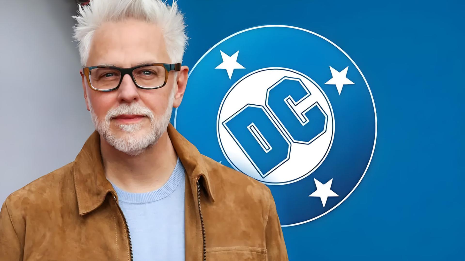 جیمز گان (James Gunn) در مقابل لوگوی شرکت دی‌سی (DC)