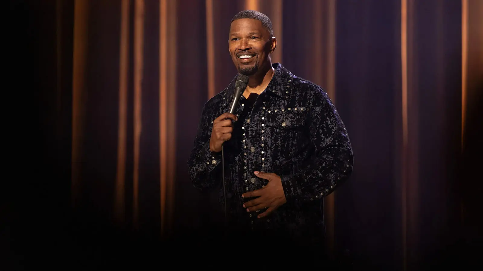 جیمی فاکس (Jamie Foxx) با میکروفون در حال اجرای استندآپ کمدی روی صحنه