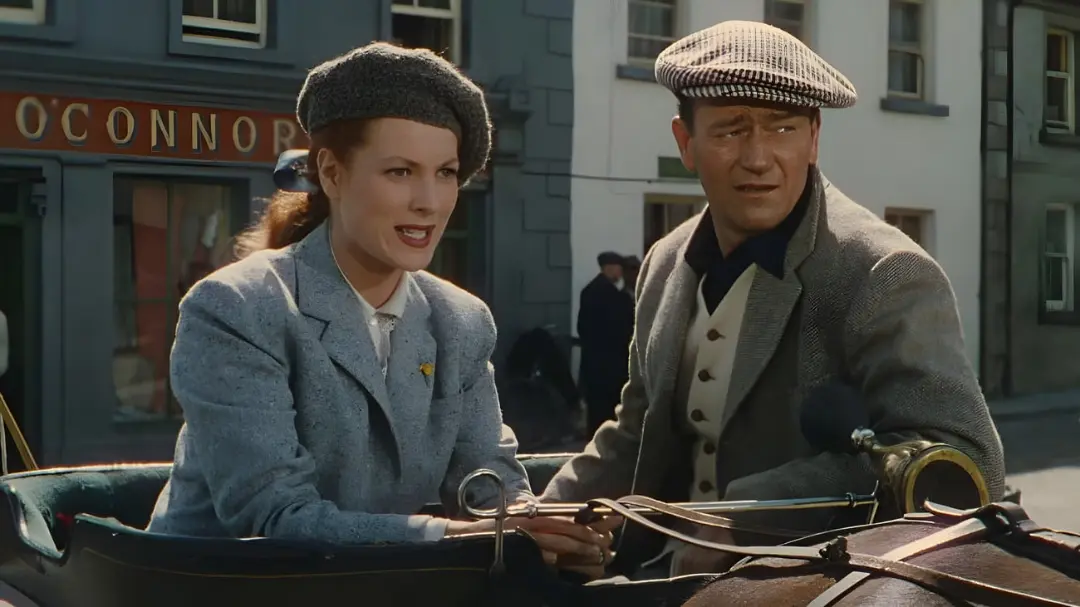 جان وین (John Wayne) و بازیگر زن در یک کالسکه در خیابان