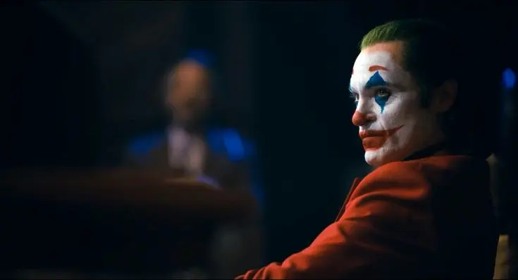 چهره جوکر (Joker) با آرایش سفید و لبخند قرمز در تاریکی