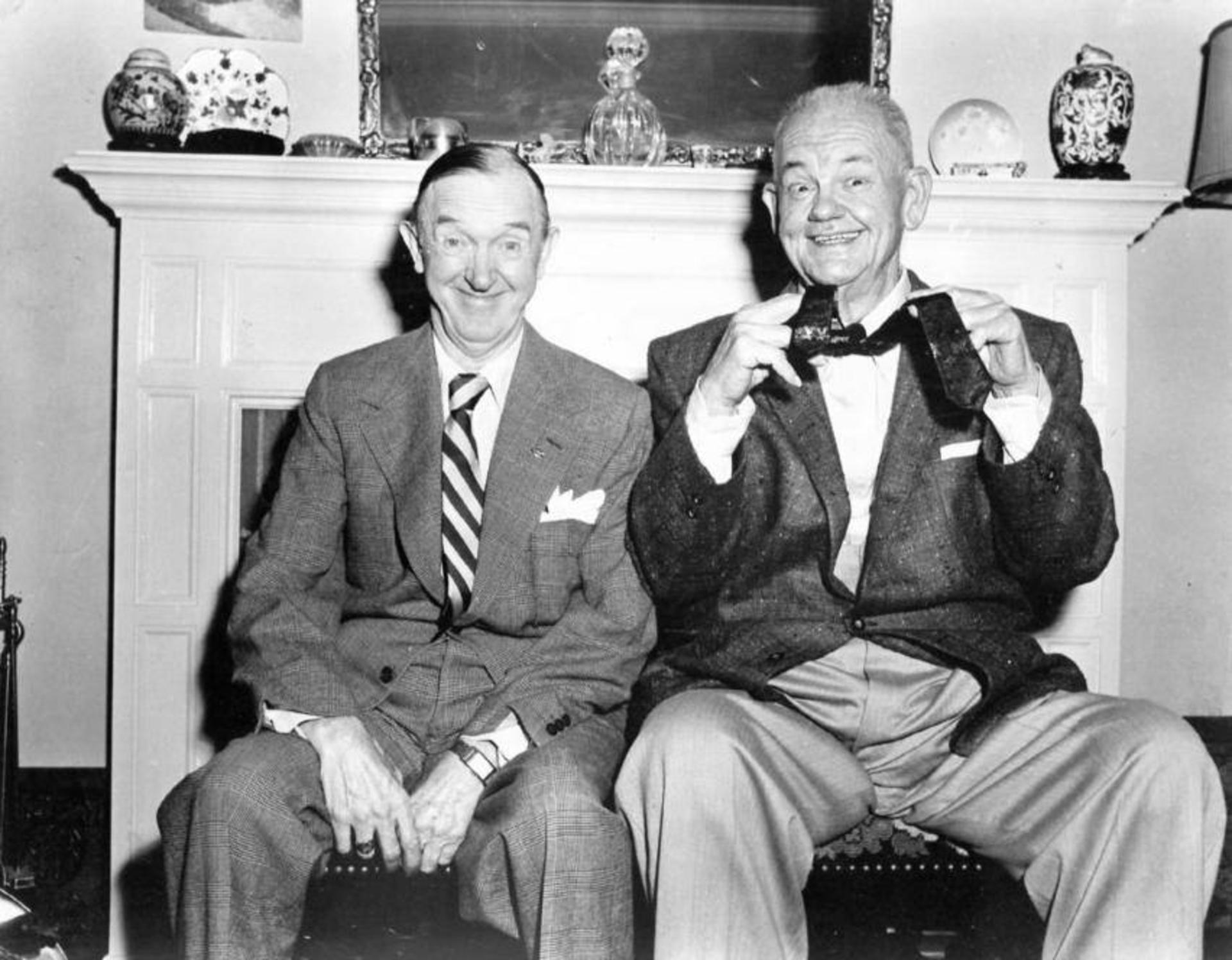 استن لورل (Stan Laurel) و اولیور هاردی (Oliver Hardy) در کنار یک شومینه