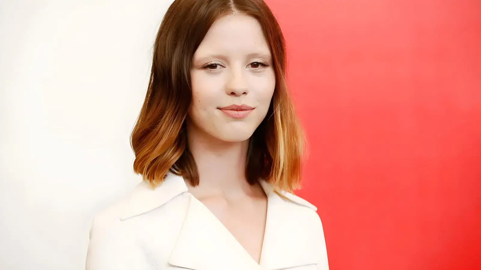 چهره میا گات (Mia Goth) بازیگر فیلم اودیسه در مقابل پس‌زمینه قرمز و سفید