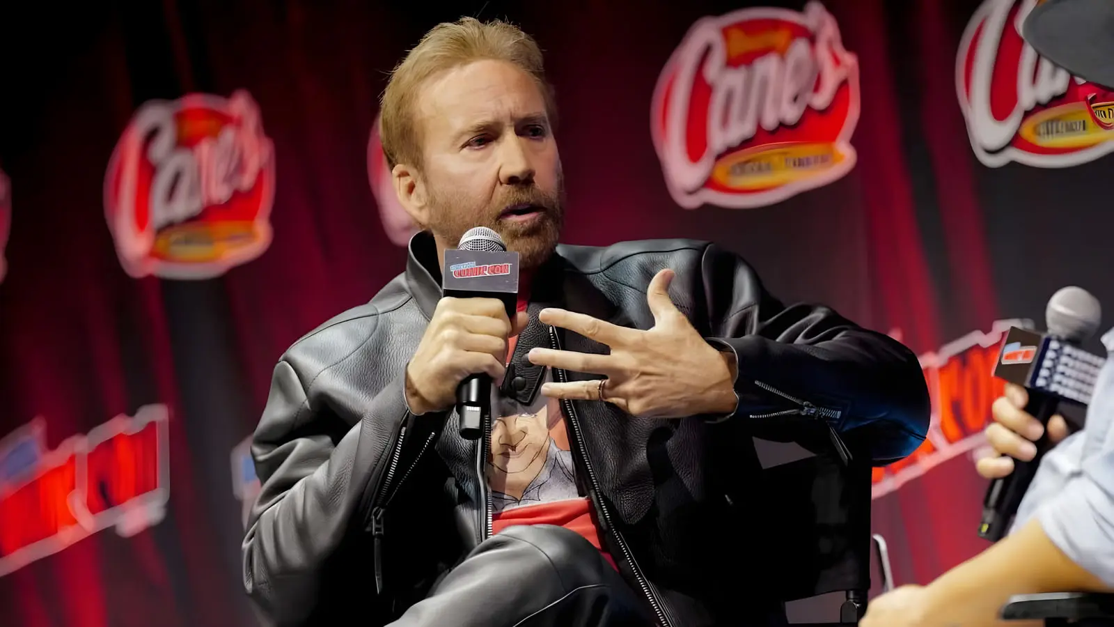 نیکلاس کیج (Nicolas Cage) در حال صحبت با میکروفون در رویداد کمیک‌کان