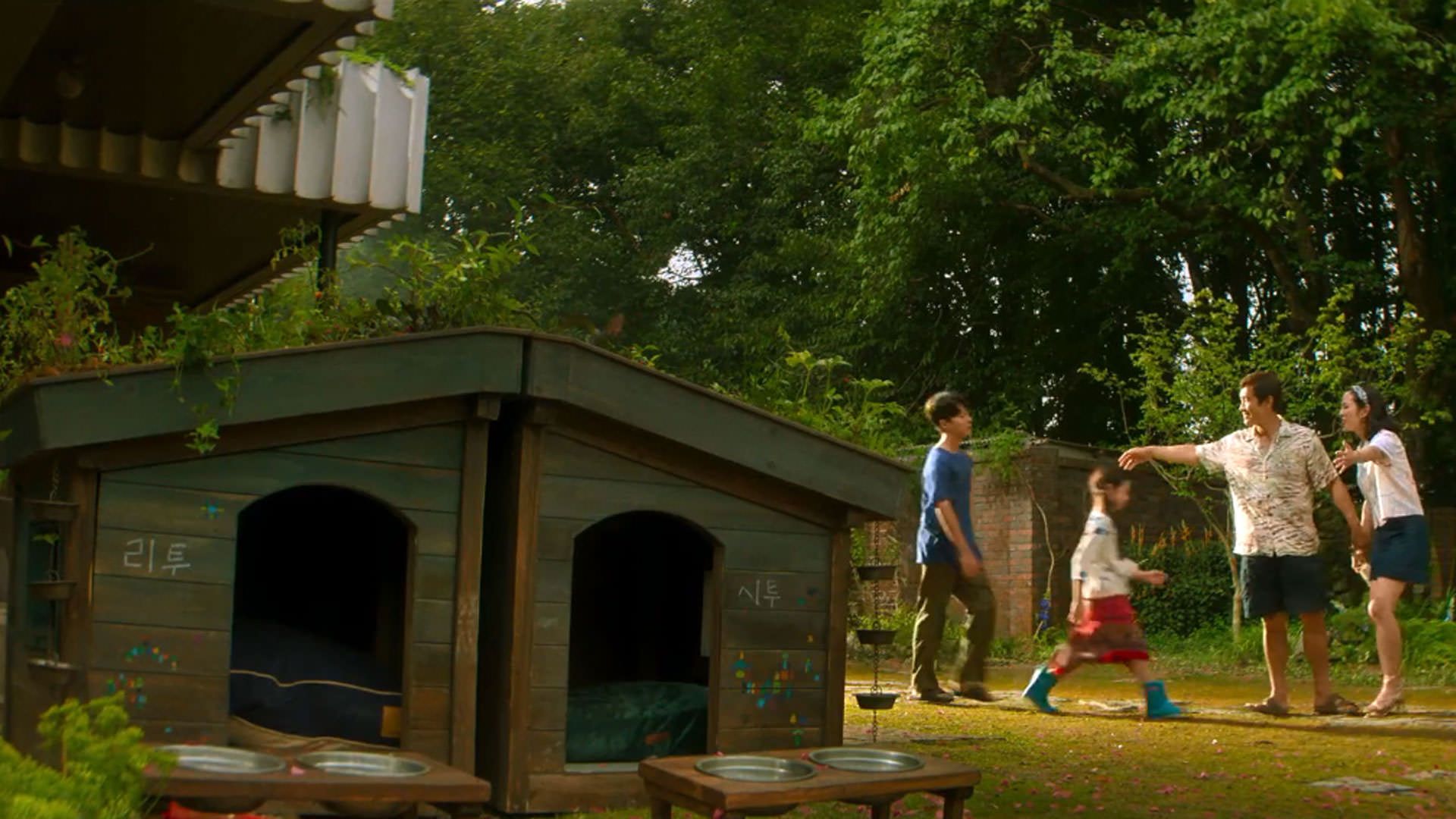 حیاط یک خانه‌ی بزرگ که خانه‌ای کوچک برای سگ‌ها دارد در نمایی از فیلم چاره‌ای نیست به کارگردانی پارک چان ووک