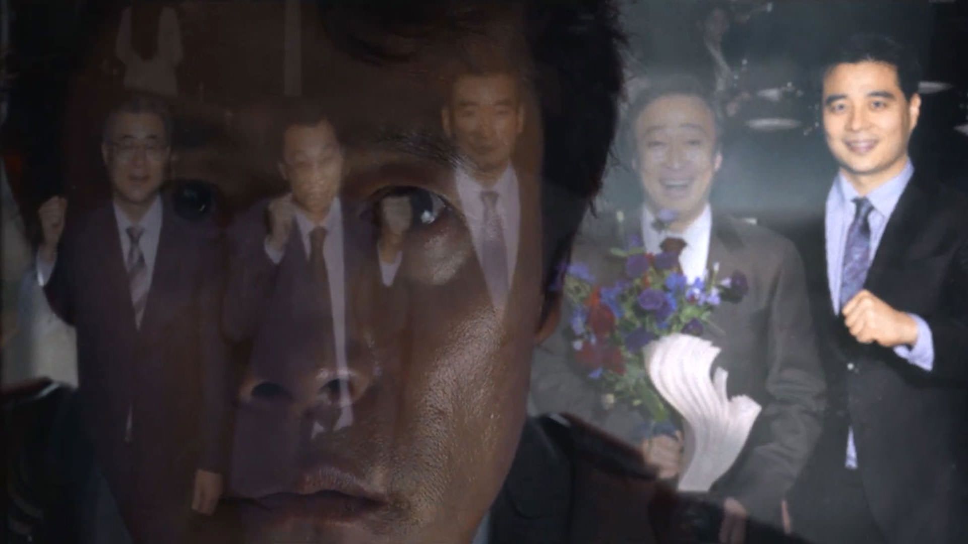 بازتاب تصویر لی بیونگ هون در یک قاب عکس در نمایی از فیلم چاره‌ای نیست به کارگردانی پارک چان ووک