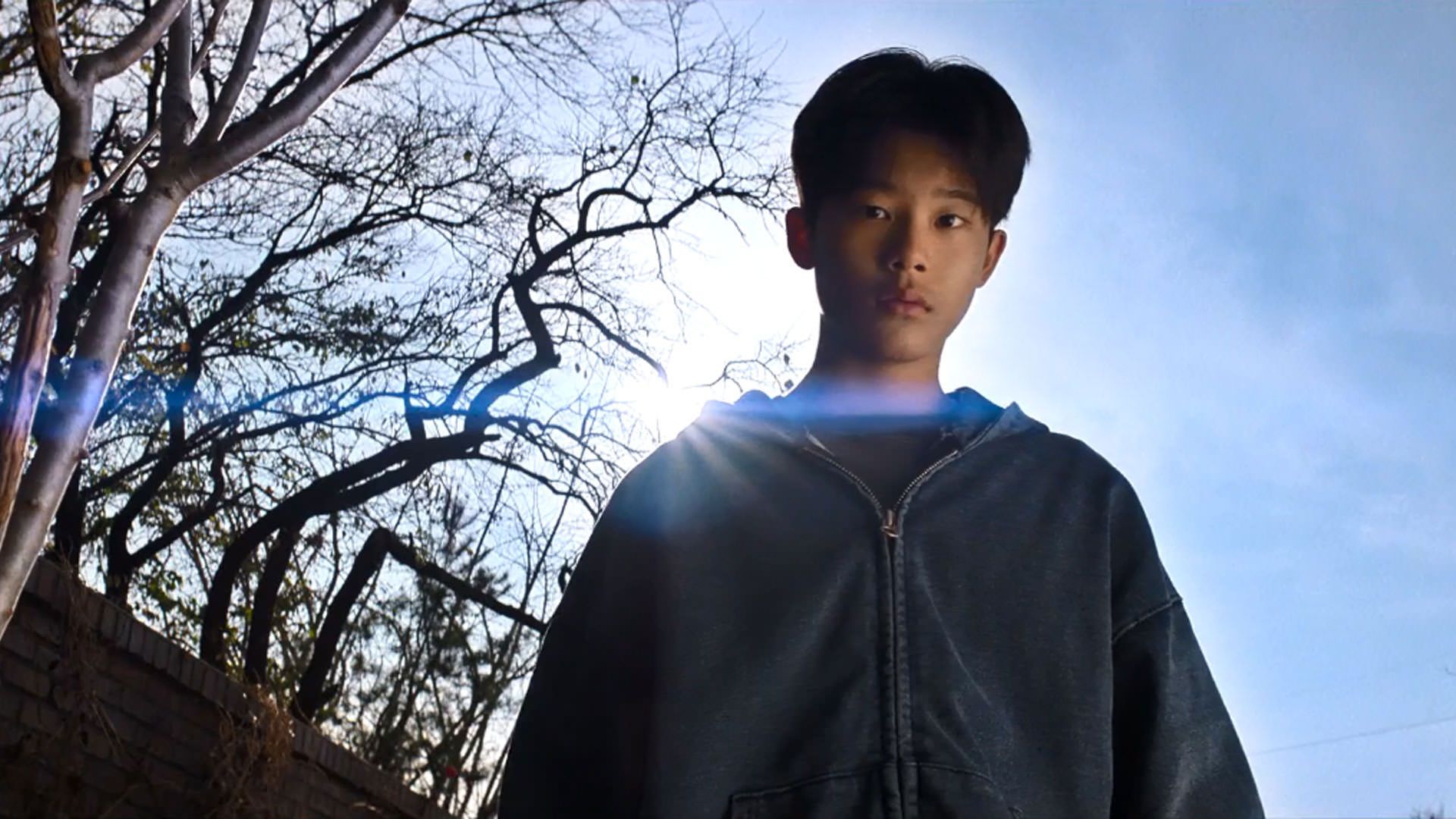 پسری نوجوان را از پایین می‌بینیم که خورشید پشت سرش است در نمایی از فیلم چاره‌ای نیست به کارگردانی پارک چان ووک