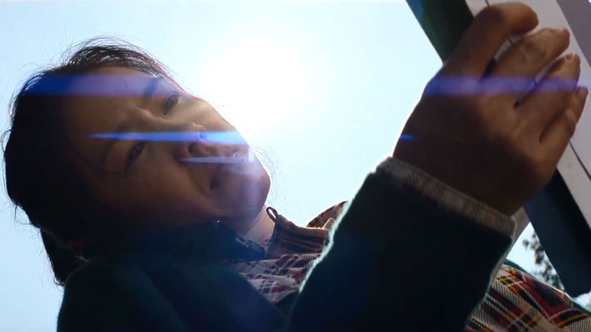 نمایی از پایین از سون یه جین که کاغذی را می‌خواند و خورشید پشت سرش دیده می‌شود در نمایی از فیلم چاره‌ای نیست به کارگردانی پارک چان ووک