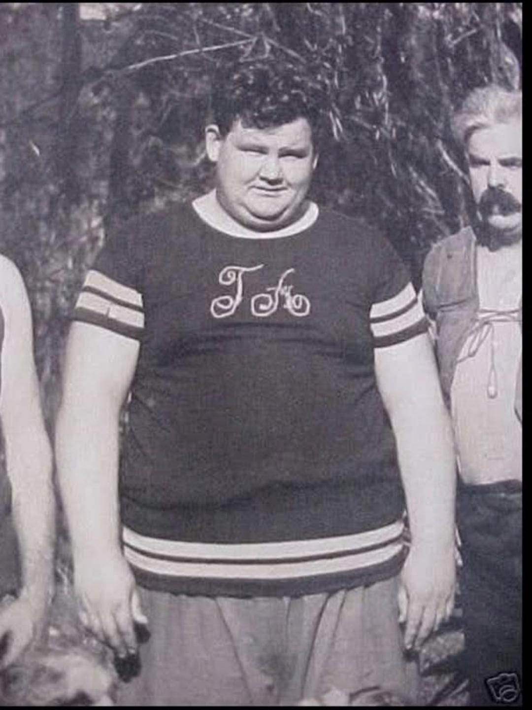 اولیور هاردی (Oliver Hardy) با تی‌شرت تیره در فضای باز