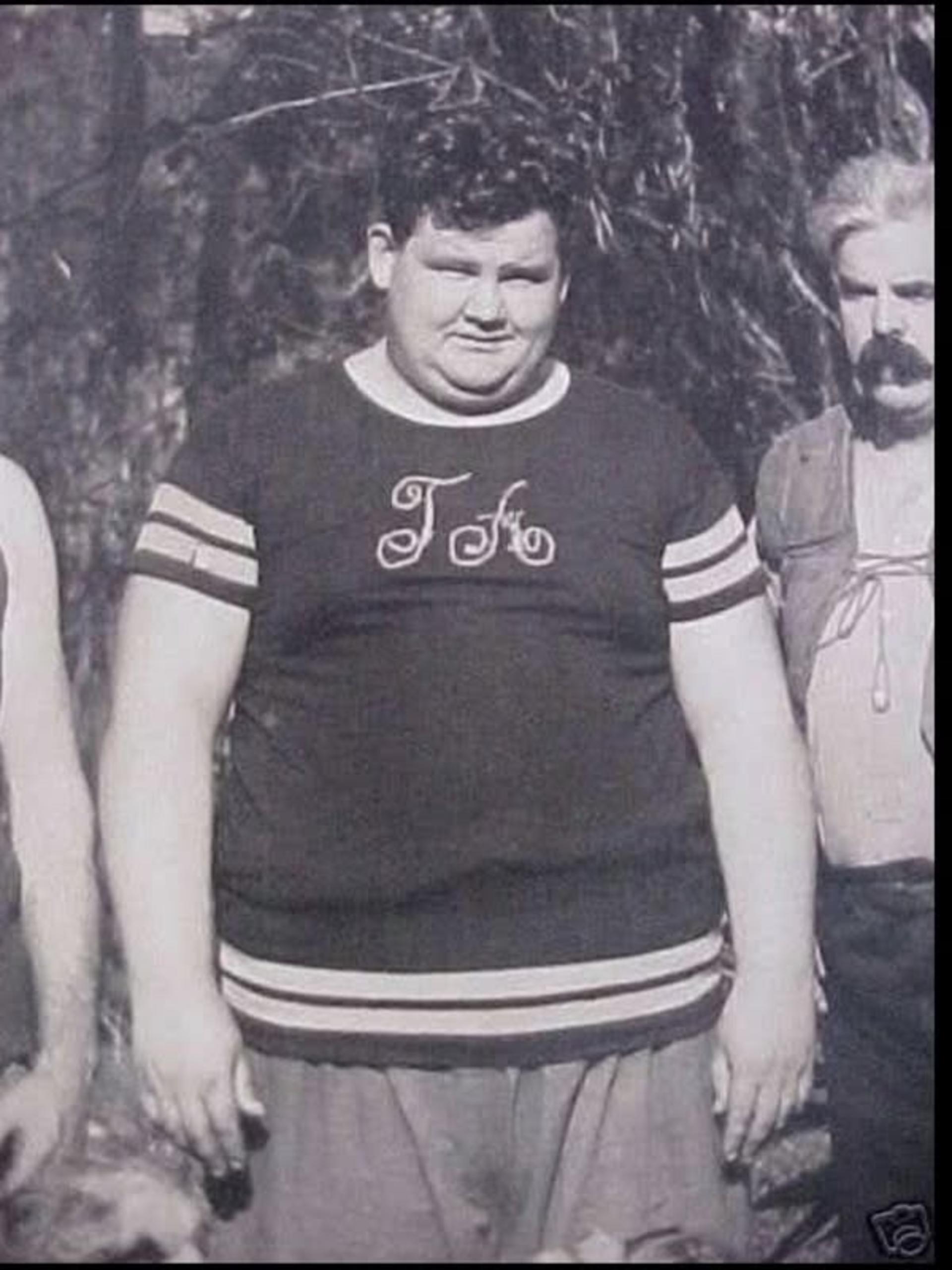 اولیور هاردی (Oliver Hardy) با تی‌شرت تیره در فضای باز