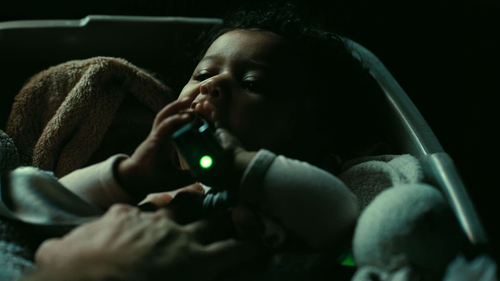 یک نوزاد دستگاهی با چراغ سبز را در دست دارد در نمایی از فیلم نبرد پشت نبرد پل توماس اندرسون
