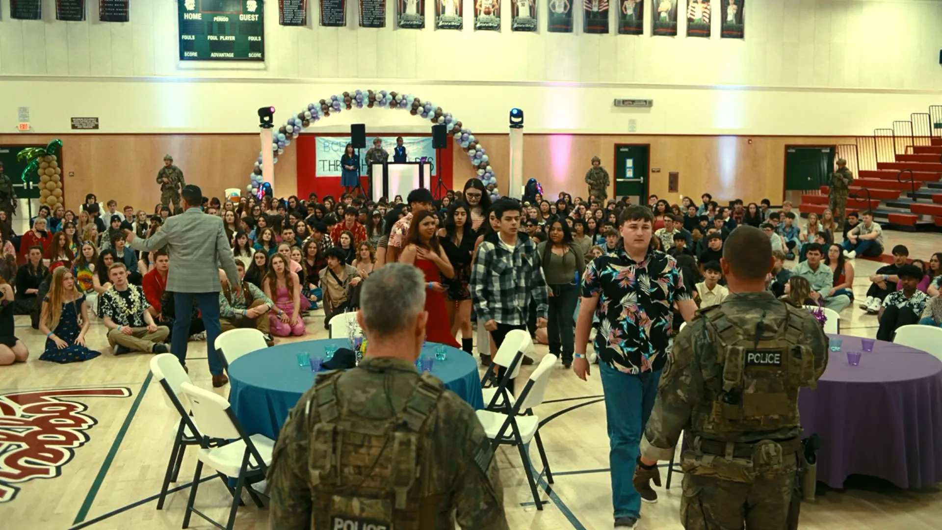 یک مهمانی داخل یک مدرسه که نظامی ها به آن سر زده‌اند در نمایی از فیلم نبرد پشت نبرد پل توماس اندرسون