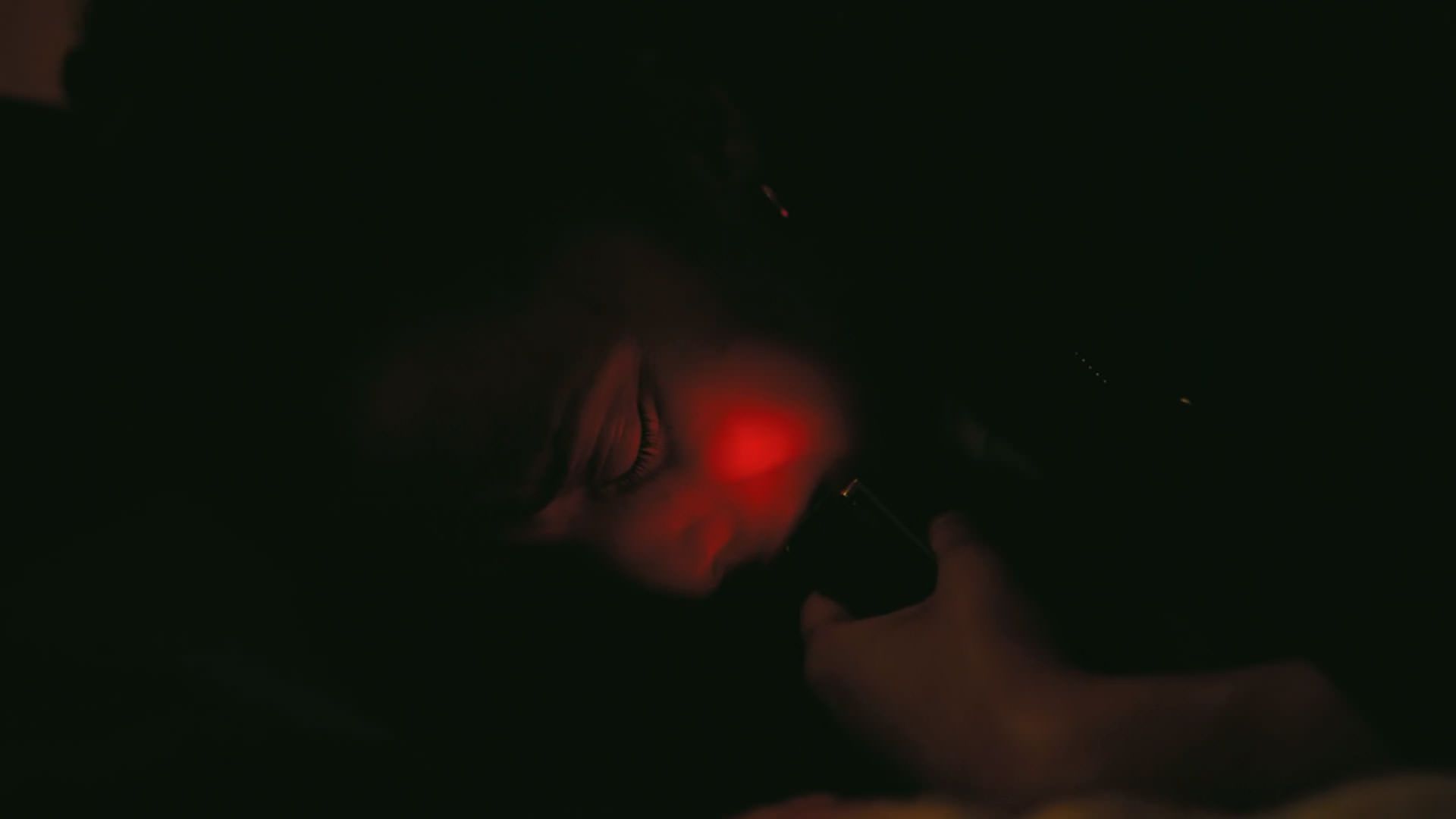 چیس اینفینیتی دستگاهی با نور قرمز را به صورتش نزدیک کرده‌ است در نمایی از فیلم نبرد پشت نبرد پل توماس اندرسون