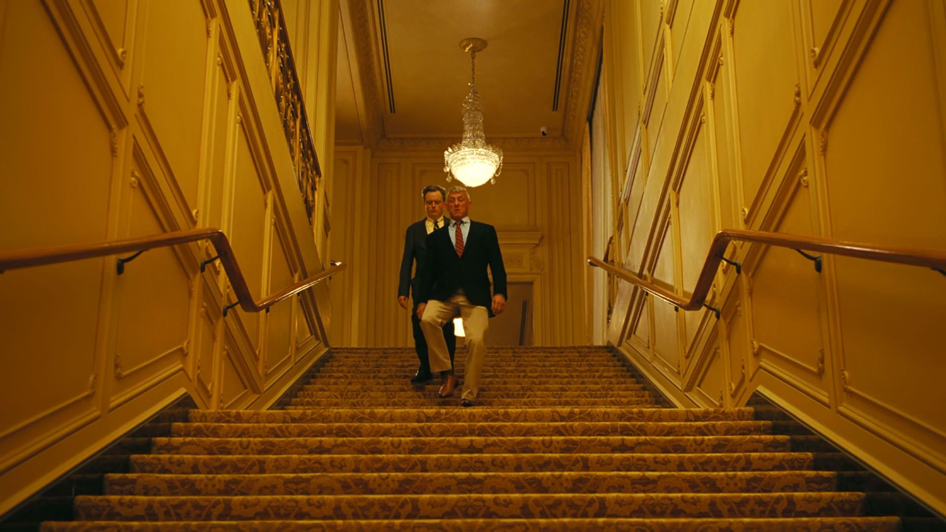 شان پن از پله‌های مکانی تالاری مجلل پایین می‌رود در نمایی از فیلم نبرد پشت نبرد پل توماس اندرسون