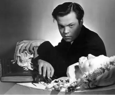 اورسن ولز (Orson Welles) در حالی که دست خود را روی یک جمجمه قرار داده است