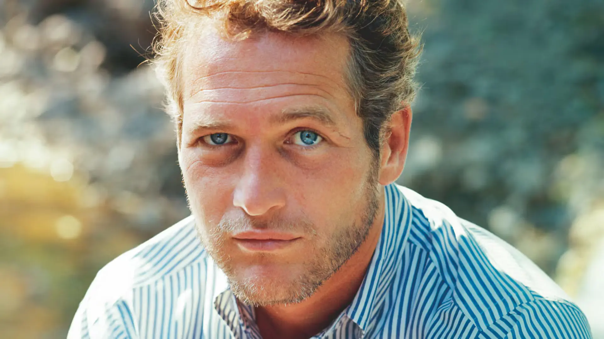 چهره نزدیک پل نیومن (Paul Newman) با چشم‌های آبی در فضای باز